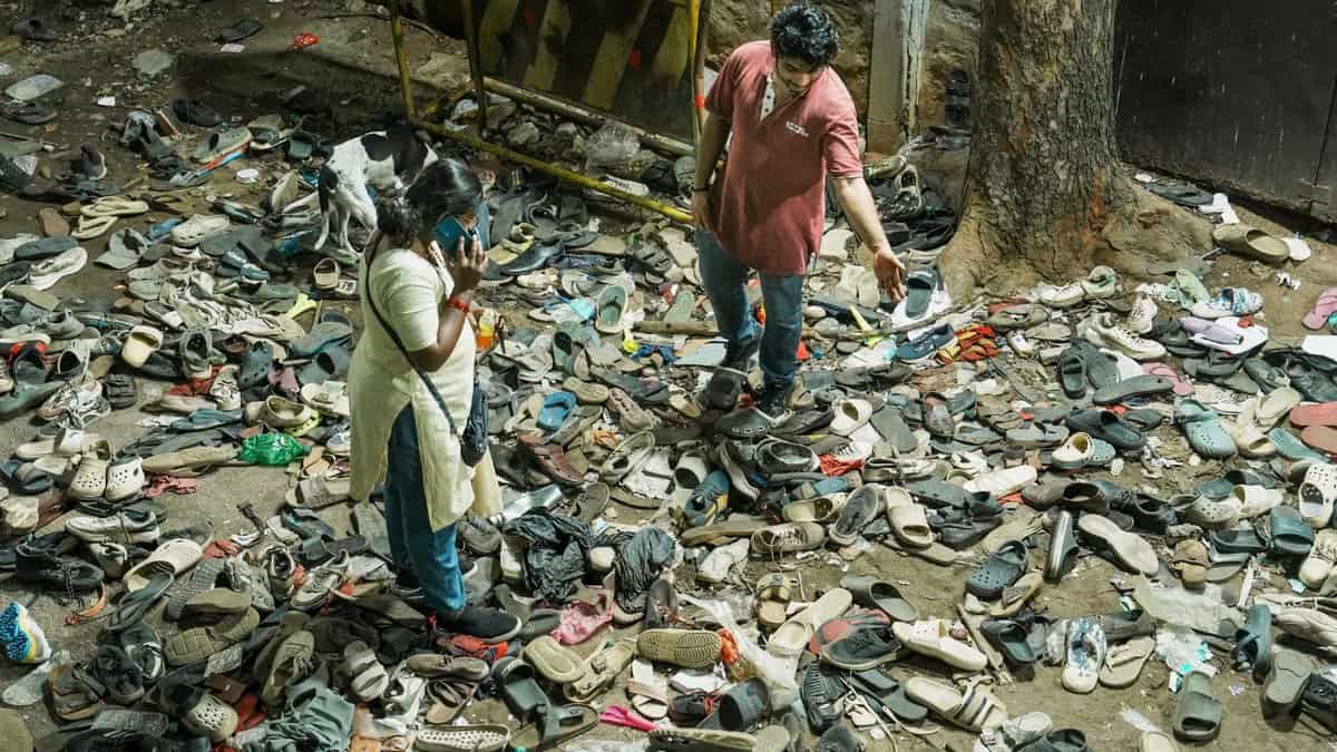 The image displays a picture of footwears lie on the ground outside the Chinnaswamy Stadium following a stampede after a large number of fans gathered for the felicitation of IPL 2025 winning Royal Challengers Bengaluru team in Bengaluru on Wednesday. At least 11 people were killed and 33 others suffered injuries in the incident (PTI)