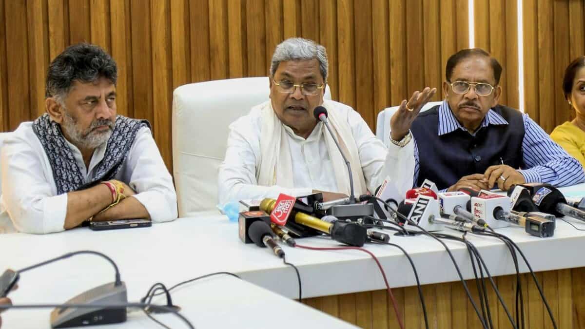 The image displays a press conference with the Karnataka CM Siddarammaiah, Deputy Cm DK Shivakumar and state home minister G Parameshwara