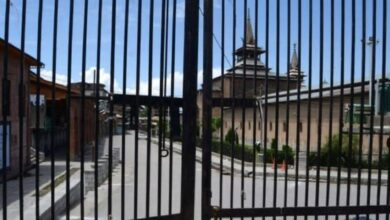 The image displays a picture of a closed Jama Masjid in Srinagar
