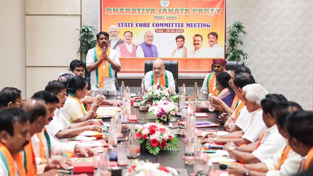 The image displays a picture of Amit Shah Shah chairing a meeting of the state core committee of the Tamil Nadu BJP.