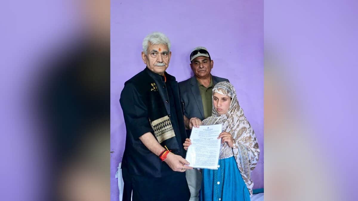 The image displays a picture of J-K Lieutenant Governor Manoj Sinha handing over the appointment letter to Adil Shah’s wife, Gulnaz Akhter