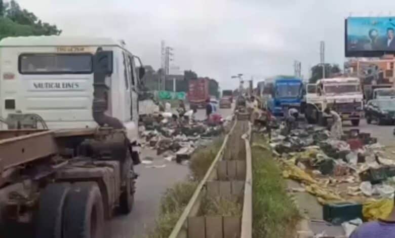 The image displays a picture of an overturned truck and scattered mangoes