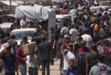 Palestinians carry bags containing food and humanitarian aid packages delivered by the Gaza Humanitarian Foundation in southern Gaza Strip on Sunday