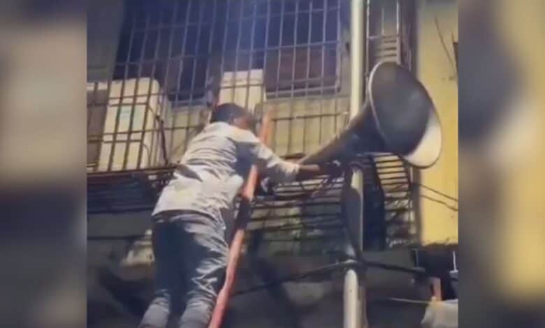 Mumbai police officer removing a loudspeaker in a mosque in the city