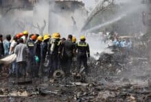 The image of Firefighters attempt to extinguish flames at the crash site of an Air India Boeing 787 Dreamliner in Ahmedabad, India, on 12 June, surrounded by debris and thick smoke.