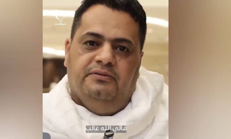 Amer al-Gaddafi, a Libyan pilgrim, smiling while seated, wearing white Ihram clothes during Haj in Makkah.