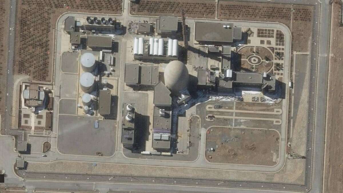 A satellite image shows the Arak heavy water reactor in Iran. The facility includes large cylindrical tanks, a domed reactor building, and various support structures, surrounded by access roads and sparse vegetation.