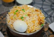 The image displays a picture of biryani with an egg