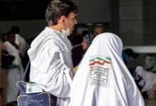 The image of a Iranian Haj pilgrims ihram attire at a gathering point, with identification tags visible on their clothing during Haj 2025 in Saudi Arabia.