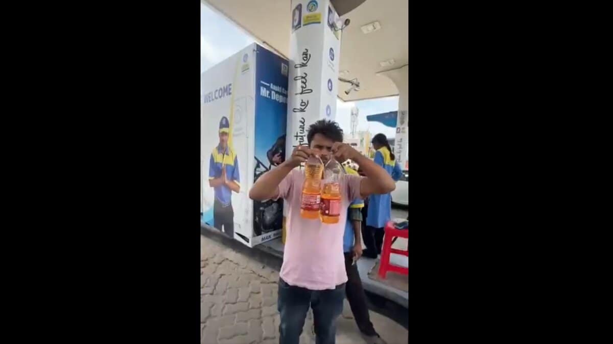 Man holds bottles at petrol pump in Hyderabad.