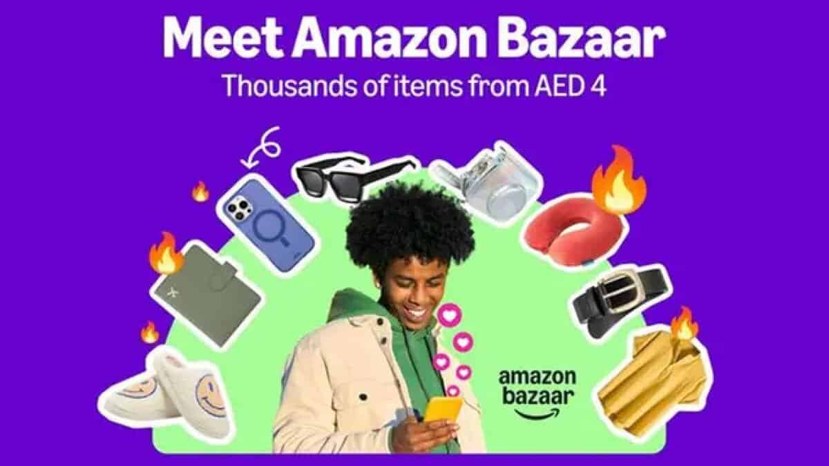 A promotional image for Amazon Bazaar featuring a smiling person with curly hair holding a smartphone, surrounded by various products including a phone case, sunglasses, slippers, a belt, a shirt, a travel pillow, and a wallet, with flames and heart emojis. The background is purple, and the text reads