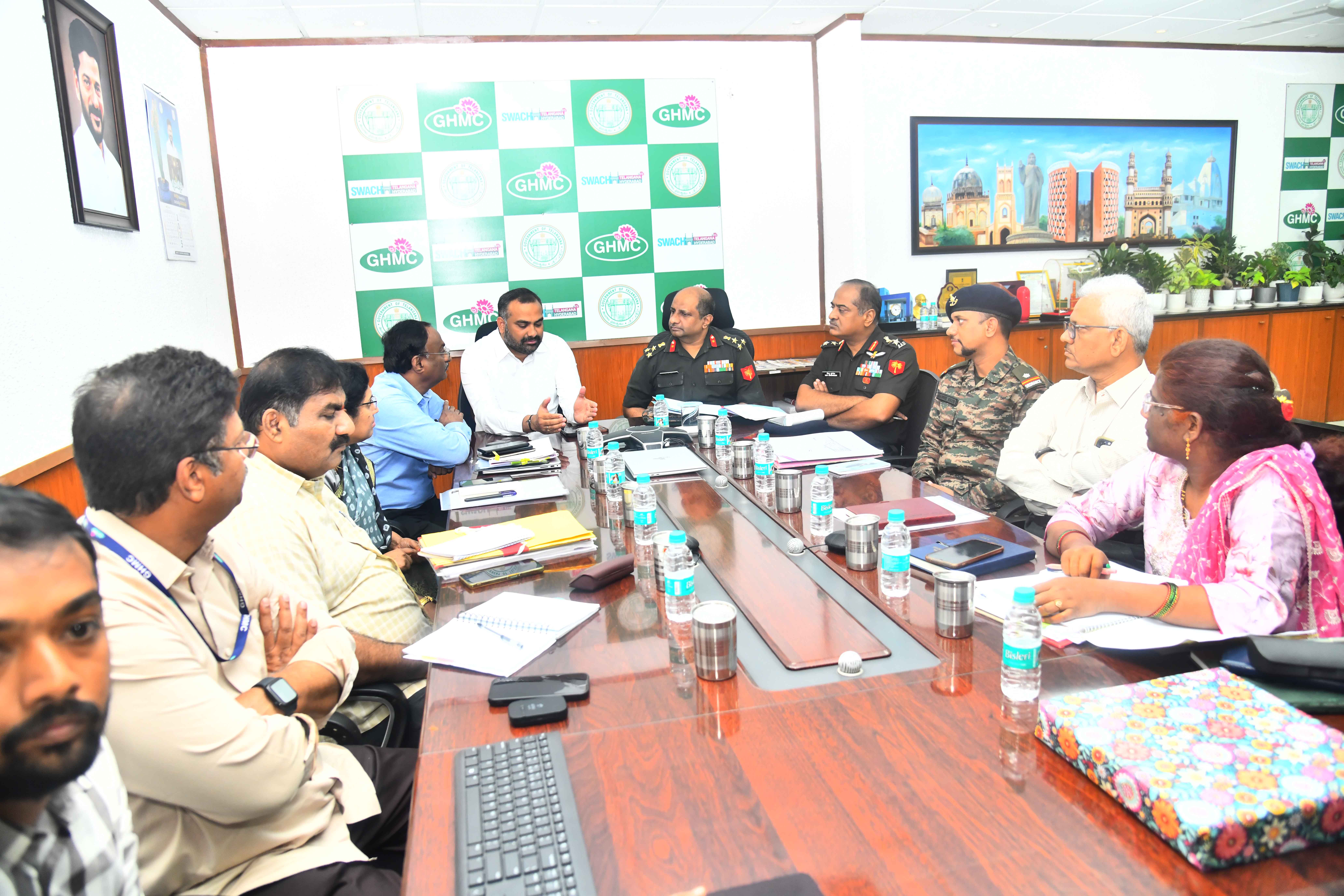 Image of GHMC officials with Defence officials discussing transfer of land.