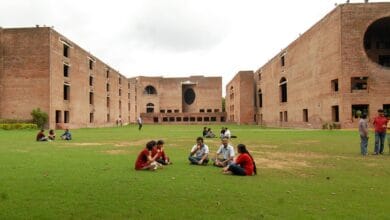 Students sitting on the lawn at the iconic red-brick campus of IIM Ahmedabad.