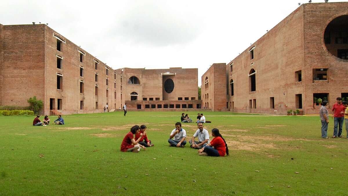 Students sitting on the lawn at the iconic red-brick campus of IIM Ahmedabad.
