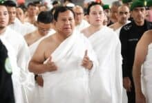 A group of men dressed in white pilgrimage garments, with Indonesian President Prabowo Subianto as the central figure gesturing with both hands, performing the Umrah pilgrimage at the Grand Mosque in Makkah.