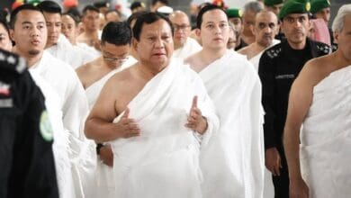 A group of men dressed in white pilgrimage garments, with Indonesian President Prabowo Subianto as the central figure gesturing with both hands, performing the Umrah pilgrimage at the Grand Mosque in Makkah.