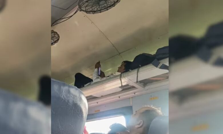 Man uses luggage rack as berth on train