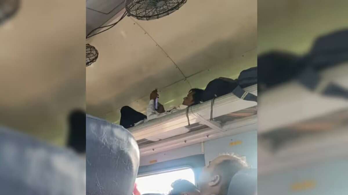 Man uses luggage rack as berth on train
