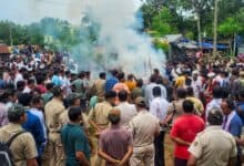 Police personnel stand guard as mortal remains of the college student, who set herself ablaze