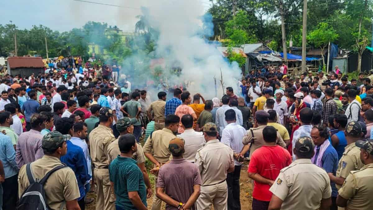 Police personnel stand guard as mortal remains of the college student, who set herself ablaze