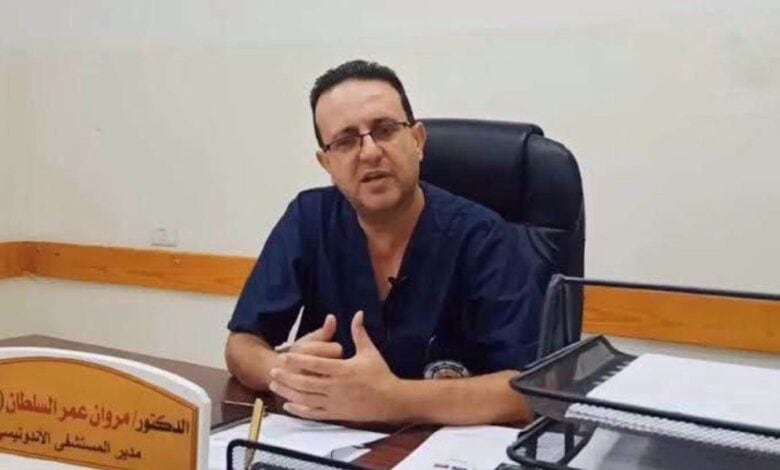 The image of Dr Marwan al-Sultan, former director of the Indonesian Hospital in Gaza, sits at his desk wearing navy blue medical scrubs.