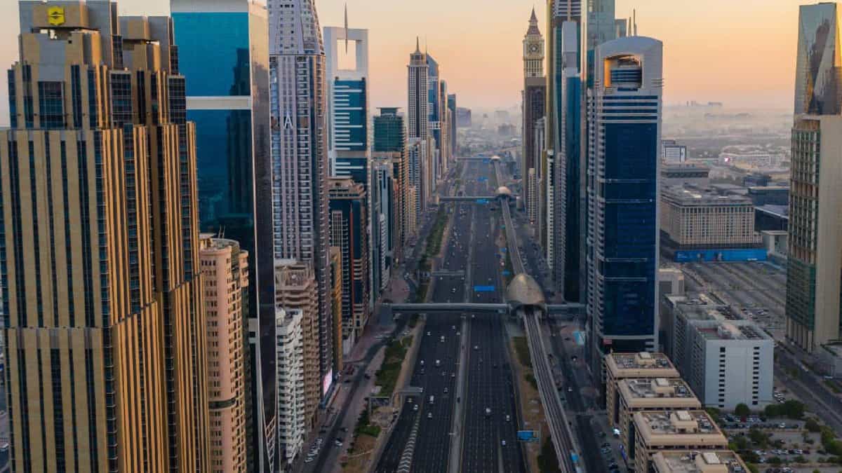 Aerial view of Sheikh Zayed Road in Dubai lined with supertall skyscrapers on both sides during sunset.