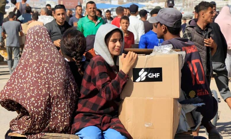 Displaced Palestinians receive aid boxes in Rafah, southern Gaza Strip.