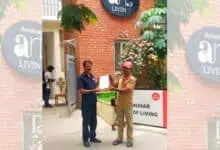 A postman hands over the GHMC order to a security guard at a gated community