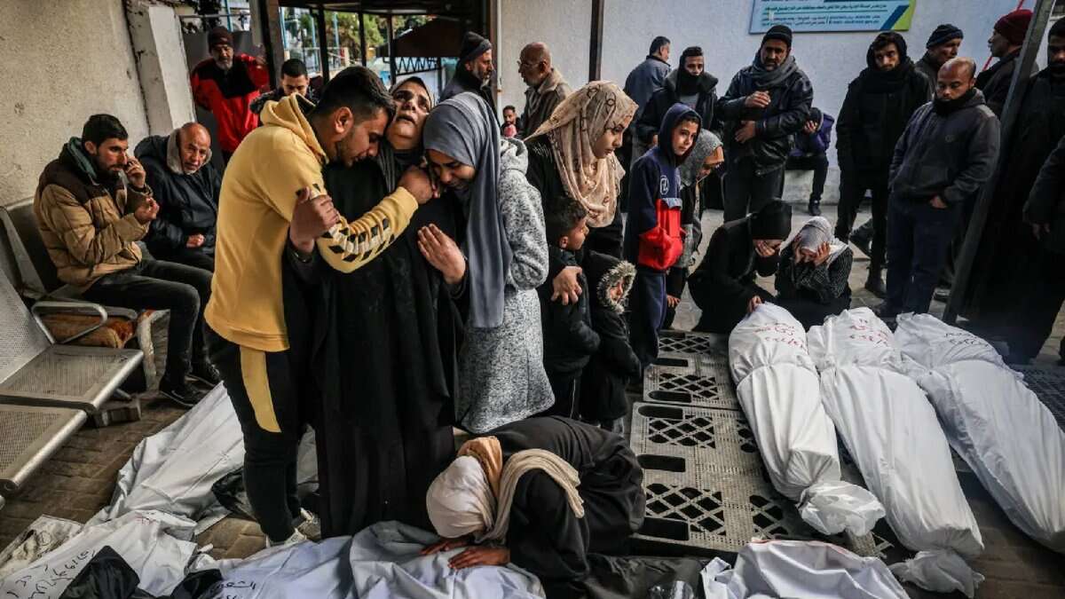 Palestinians mourning over the bodies of relatives, covered in white shrouds, killed in an overnight Israeli bombardment, at al-Najjar Hospital in Rafah.