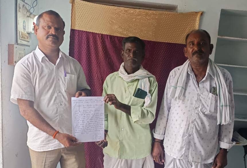 Swadesh Parikipandla stands beside Gorre Rajendhar’s father, who holds a written appeal, seeking help for his son stranded in Dubai.