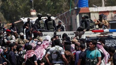 Security forces stand on armoured vehicles blocking armed Bedouin fighters gathered in front of them during a tense standoff near Sweida, Syria.