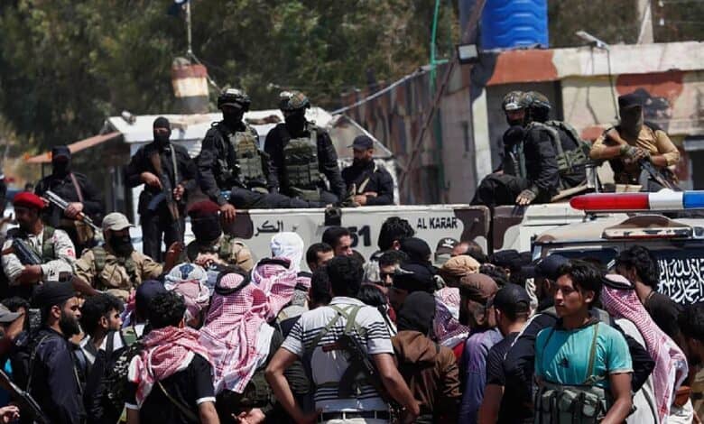 Security forces stand on armoured vehicles blocking armed Bedouin fighters gathered in front of them during a tense standoff near Sweida, Syria.
