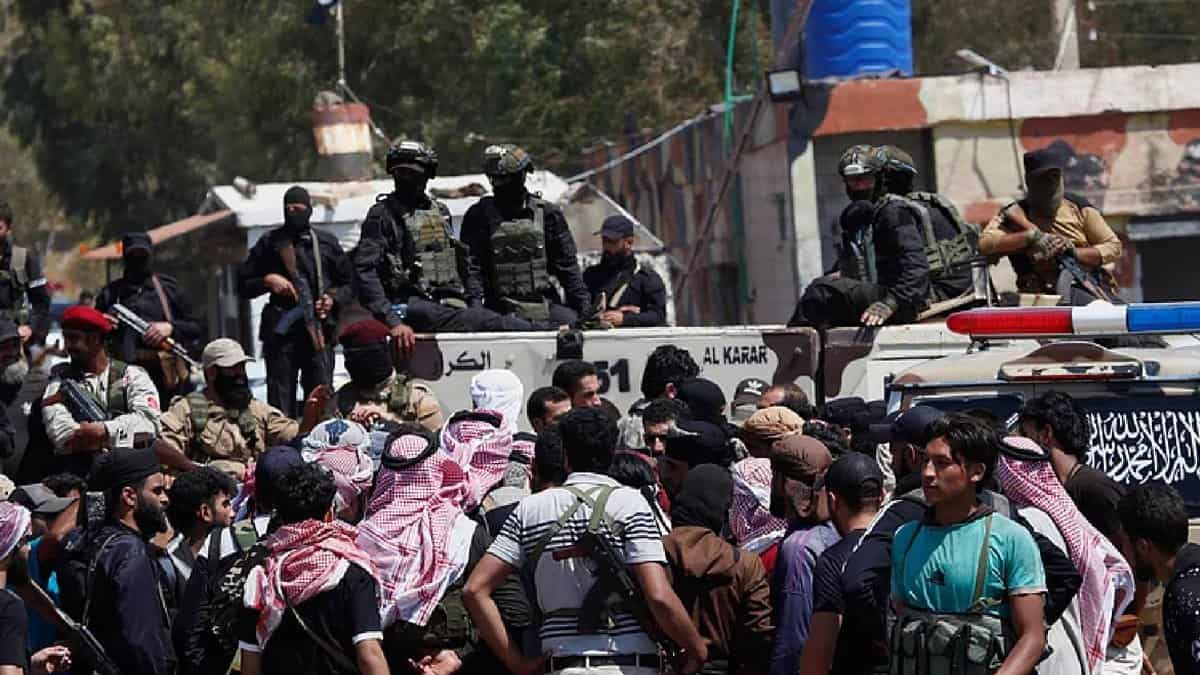Security forces stand on armoured vehicles blocking armed Bedouin fighters gathered in front of them during a tense standoff near Sweida, Syria.