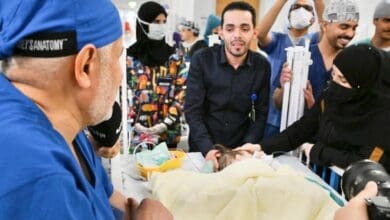 Doctors and family members surround one of the separated Syrian conjoined twins in a hospital room after the successful surgery.