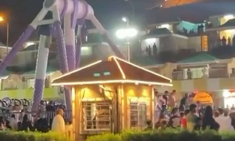 Crowds gather around a collapsed amusement park ride at night in Green Mountain Park, Taif, Saudi Arabia, following a mechanical failure.
