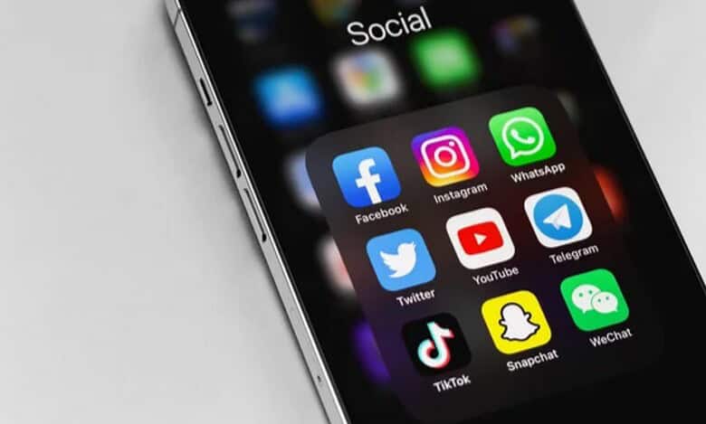 Smartphone screen displaying popular social media app icons including Facebook, Instagram, WhatsApp, Twitter, YouTube, Telegram, TikTok, Snapchat, and WeChat.