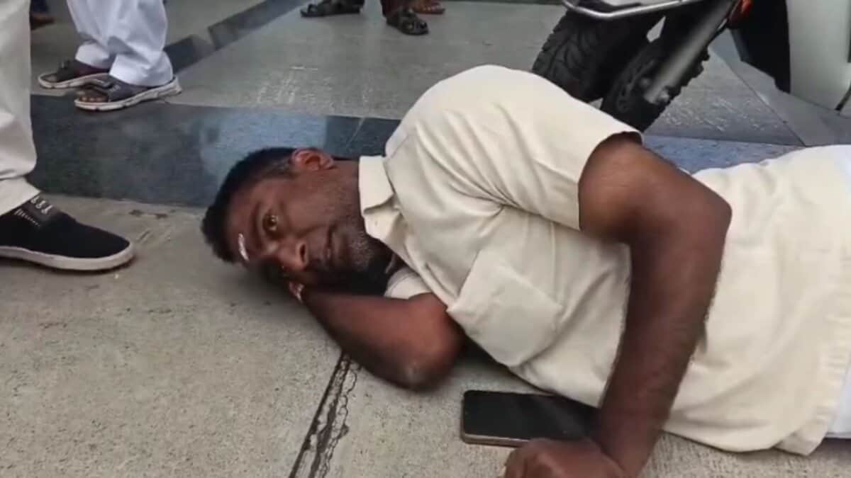 The image shows Raja Gangaram, a differently-abled person, lying on the floor and protesting after being humiliated when he tried to meet Jagtial distirct collector during Prajavani on Monday, August 11, 2025.