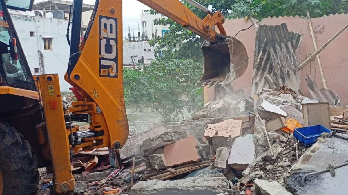 The image shows HYDRAa officials demolishing illegal structures on a nala between Pariki Cheruvu and Kukatpally in Medchal-Malkajgiri district on Monday, August 18, 2025.