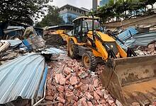 The image shows HYDRAA officials demolishing illegal encroachments from government land in Madhapur on Wednesday, August 20.