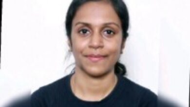 Sweety Stanly, smiling slightly, with a plain white background. She has tied-back hair and is wearing a dark top.