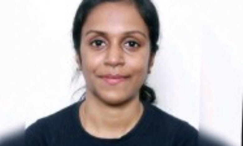Sweety Stanly, smiling slightly, with a plain white background. She has tied-back hair and is wearing a dark top.