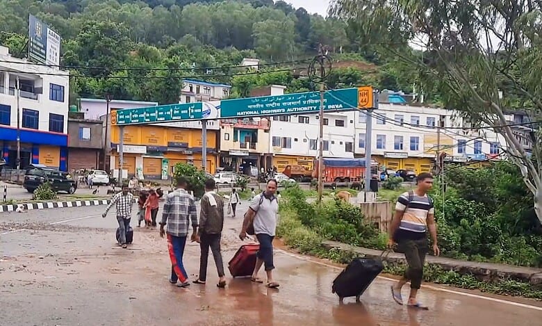 Udhampur: People with their luggage as two bridges on the Jammu-Srinagar National Highway damaged due to heavy rainfall, in Udhampur, Wednesday, Aug. 27, 2025. (PTI Photo)