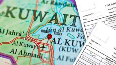 Map of Kuwait with visa application forms in the foreground.