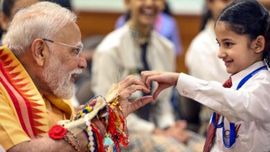 PM Modi interacts with a child during Raksha Bandhan festival celebration