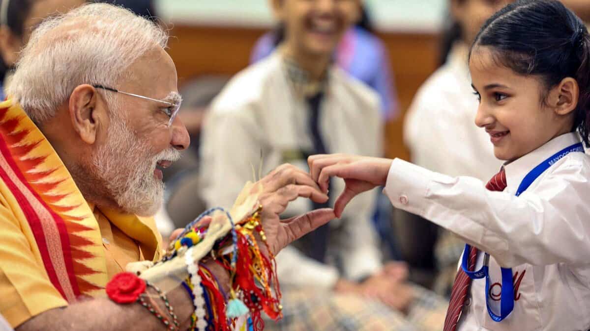 PM Modi interacts with a child during Raksha Bandhan festival celebration
