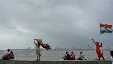People at Marine Drive as dark clouds hover in the sky, in Mumbai, , Aug. 20, 2025.