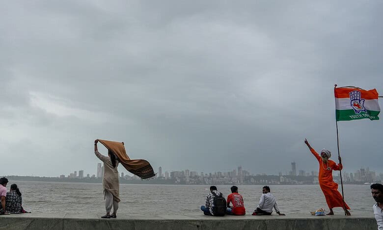 People at Marine Drive as dark clouds hover in the sky, in Mumbai, , Aug. 20, 2025.