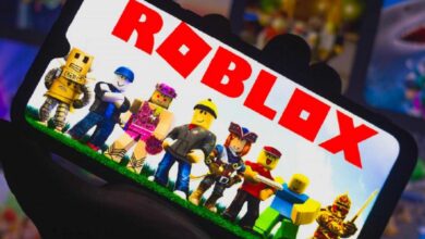 A group of Roblox characters standing on grass, displayed on a phone screen with the "ROBLOX" logo prominently shown.