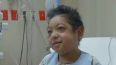 Smiling 7-year-old Saudi boy in hospital gown after heart transplant.
