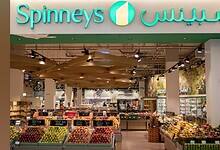 Interior view of a Spinneys supermarket showcasing fresh fruits and groceries.